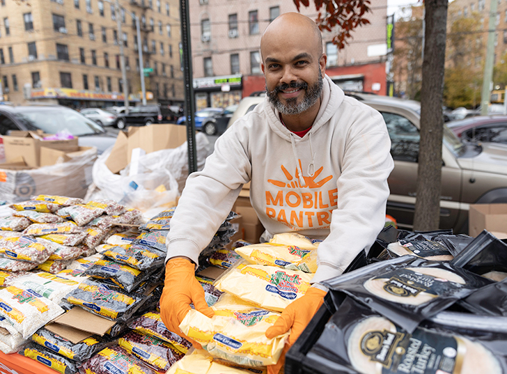 A man organizing food for a mobile pantry. Links to What to Give what.jpg