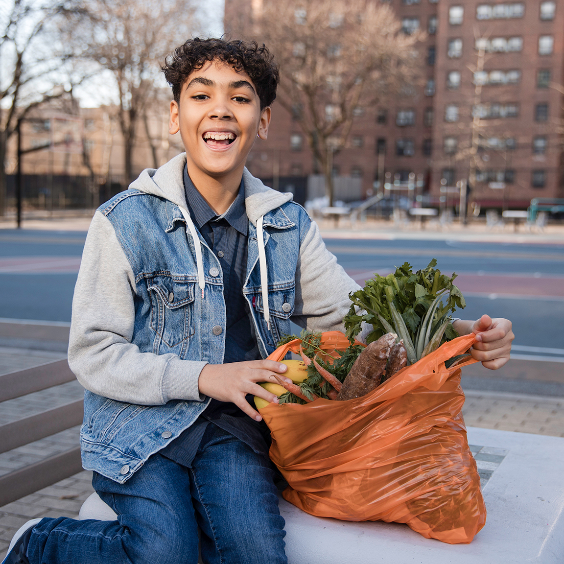 front-masthead Woman holding a donated grocery bag from community pantry